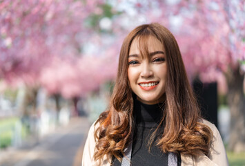 woman traveler looking cherry blossoms or sakura flower blooming in the park