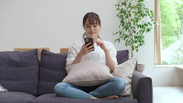携帯を触る若いアジア人女性