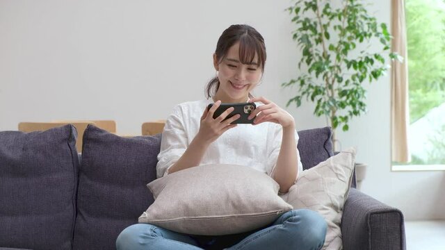 携帯を触る若いアジア人女性