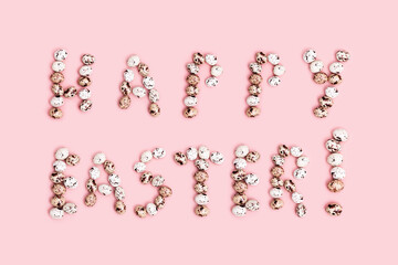 Words  Happy Easter from Chocolate Quail eggs on pastel background. Small pink egg, spring Easter holiday