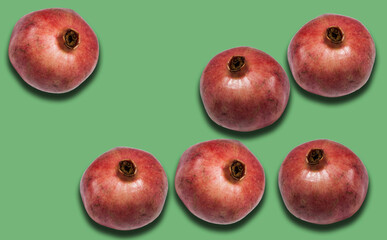 ripe red pomegranate fruit on green background with copy space for your text, healthy vegetarian diet top view.