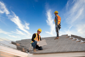 Asian engineer workers install new CPAC roof, roofing tools, electric drill, use on new roof with...