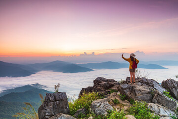 Young girl in yellow jacket hiking on the mountain, Doy-pha-tang, border  of  Thailand and Laos.