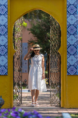 Fototapeta na wymiar Adult Asian woman in white dress walking in garden