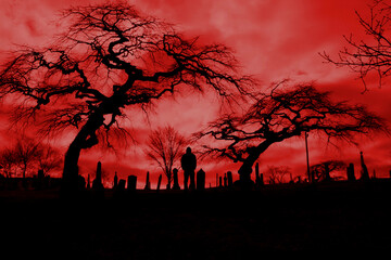 Scary pic of cemetery with hellfire sky and scary trees.  Perfect for Halloween or horror themes.