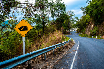 Uphill Steep Road sign. Road sign with yellow background and black illustration warning truck that uphill steep slope ahead on a curvy road.
