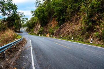 View of curvy asphalt country road along the mountains and forest.
