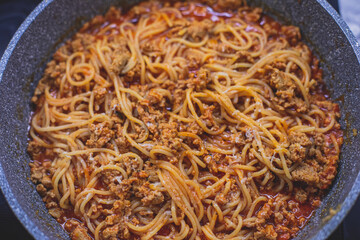 Pasta bolognese pan, homemade prepared close up view, classic italian spaghetti noodle with minced meat beef, tomato sauce and parmesan cheese