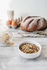 raw different grains and seeds in small plate on background of cooking homemade dishes. wellness food at home, vertical food content, selective focus