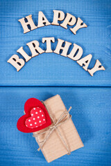 Wrapped gift with ribbon for birthday. Inscription happy birthday on boards
