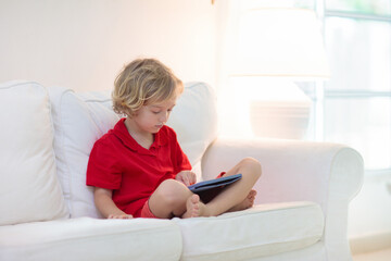 Child with tablet computer. Kids study online.