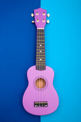 Obraz premium Four string ukulele guitar on blue background