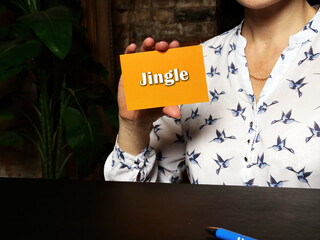Financial concept meaning Jingle with inscription on orange business card.