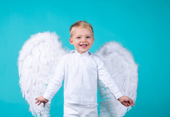 Little Valentin. Cute smiling child boy with white angel wings.