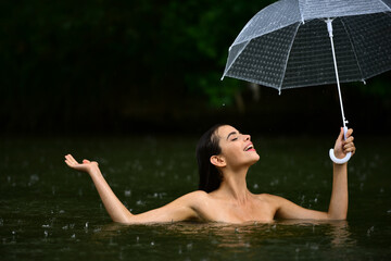 Naked girl with umbrella. Raining, flood. Autumn time.