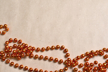 Background from beige craft paper, bottom orange round beads to decorate the Christmas tree.