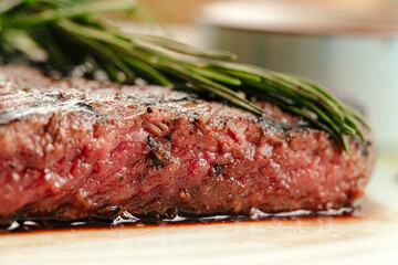 Closeup on roasted beef medium rare steak with a rosemary