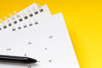 calendar month schedule to make appointment meeting or manage timetable each day lay and pen on yellow background for planning work and travel concept. 