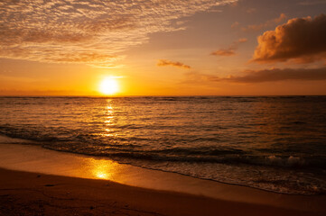 Vibrant sunset with orange and yellow colors, and some clouds painting the sky. Iriomote Island.