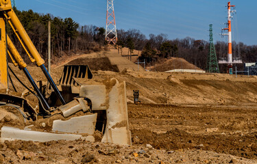 Blade and hydraulic lift cylinders of bulldozer at new construction site.
