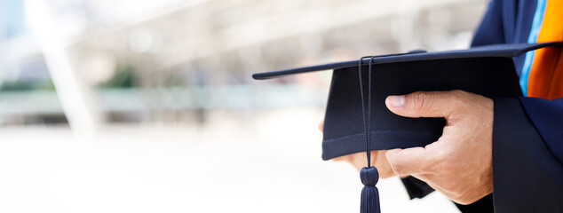 graduates ,close up student holding hats and tassel black in hand during commencement success of...