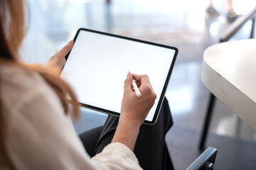 Businesswoman holding a tablet blank white screen at the office.