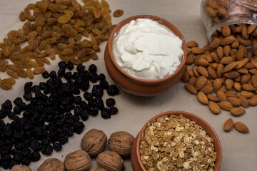 A bowel full of healthy muesli breakfast cereal and curd with blue berries walnuts almonds and raisins in a white background.
