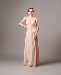 Bridesmaid's dresses. Elegant moscato dress. Beautiful pink chiffon evening gown. Studio portrait of young happy ginger woman. Transformer dress idea for an event. © Love-Pics