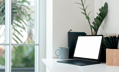 Mockup creative workspace with blank screen tablet on white top table in modern room.