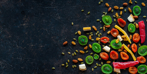 Composition of multicolored candied fruit on a dark background. View from above. A place for text.