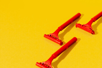 Disposable razors on yellow background, studio shot