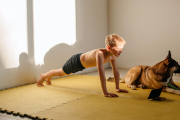 belt goes in for sports online, the boy performs push-ups at home. physical education classes via the Internet and a tablet 