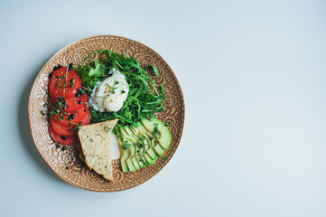 healthy diet vegetarian breakfast - poached egg, whole grain bread, tomatoes, avocado, arugula...
