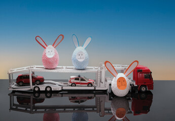 Easter eggs, bunnies and hare eggs on a tractor with a trailer