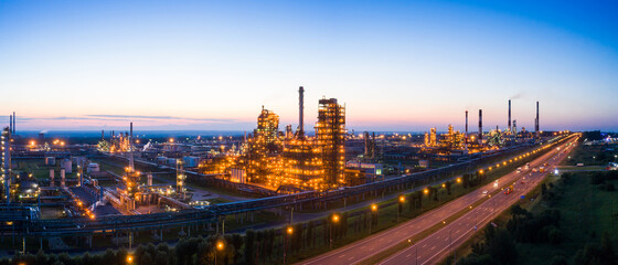 Oil refinery plant industry, Refinery factory. oil storage tank, rectification column and pipeline against the backdrop of sunset in summer, Russia.