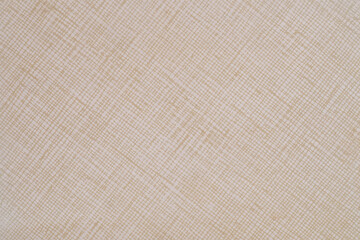 Texture of a sheet or woven fabric of beige color with light brown patterns