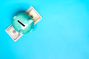 piggy bank, dollars banknote on blue background Buying, sale, investment, banking, loan, insurance concept Flat lay Top view Business and finance