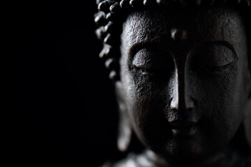 Meditating Buddha Statue isolated on black background. Copy space. 