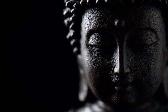 Meditating Buddha Statue isolated on black background. Copy space.	