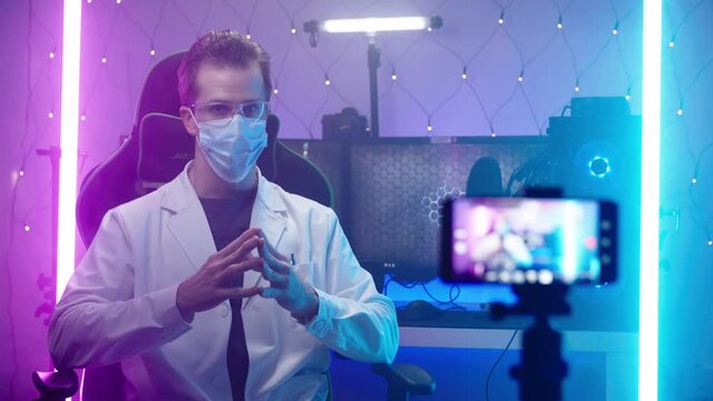 Doctor with face mask recording with smartphone in cyberspace office 4K