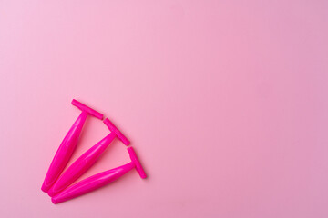 Female disposable razors on pink background top view