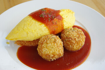 Japanese Omu Rice (fried rice with chicken and tomato sauce wrapped in egg omelet) topped with Hayashi sauce (sliced pork gravy)