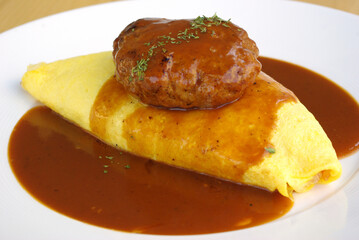 Japanese Omu Rice (fried rice with chicken and tomato sauce wrapped in egg omelet) topped with Hayashi sauce (sliced pork gravy)
