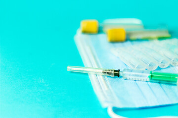 Medical vials for injection, syringe for injection, mask gloves on a blue background. Admission vaccination, flu shot.