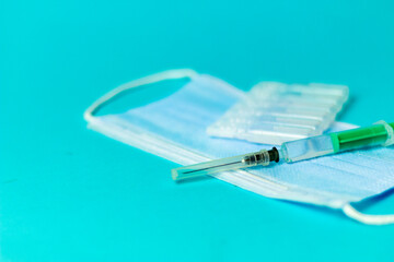 Medical vials for injection, syringe for injection, mask gloves on a blue background. Admission vaccination, flu shot.