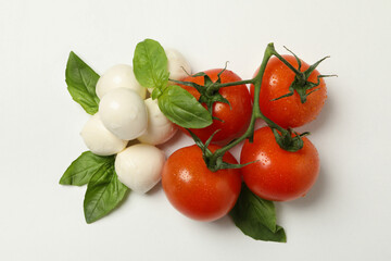 Mozzarella cheese, tomato and basil on white background
