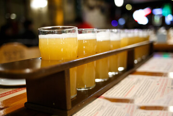 many glasses of beer on display in the pub on the table