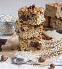 Oatmeal squares with chocolate, light concrete background. Diet bars. Healthy bakery for breakfast or dessert.
