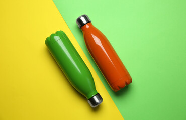 New modern thermo bottles on color background, flat lay