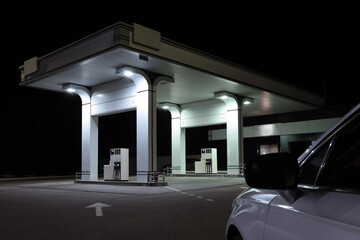 Obraz na płótnie Canvas Modern car driving to gas station at night, closeup